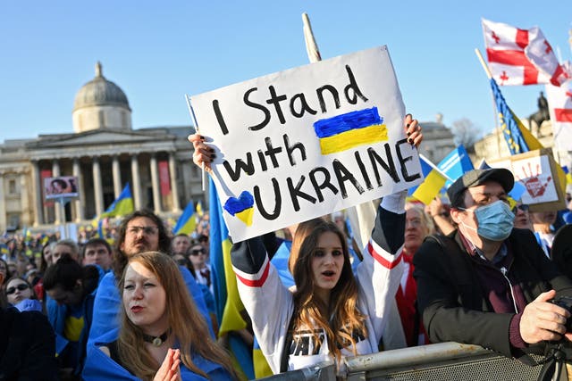 <p>People hold placards and Ukrainian national flags in Trafalgar Square during a protest march and vigil in March 2022</p>