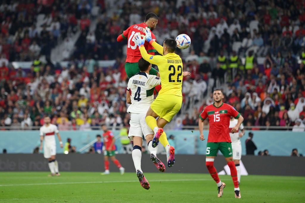 En-Nesyri of Morocco rises above goalkeeper Diogo Costa and Ruben Dias of Portugal to head in the winner