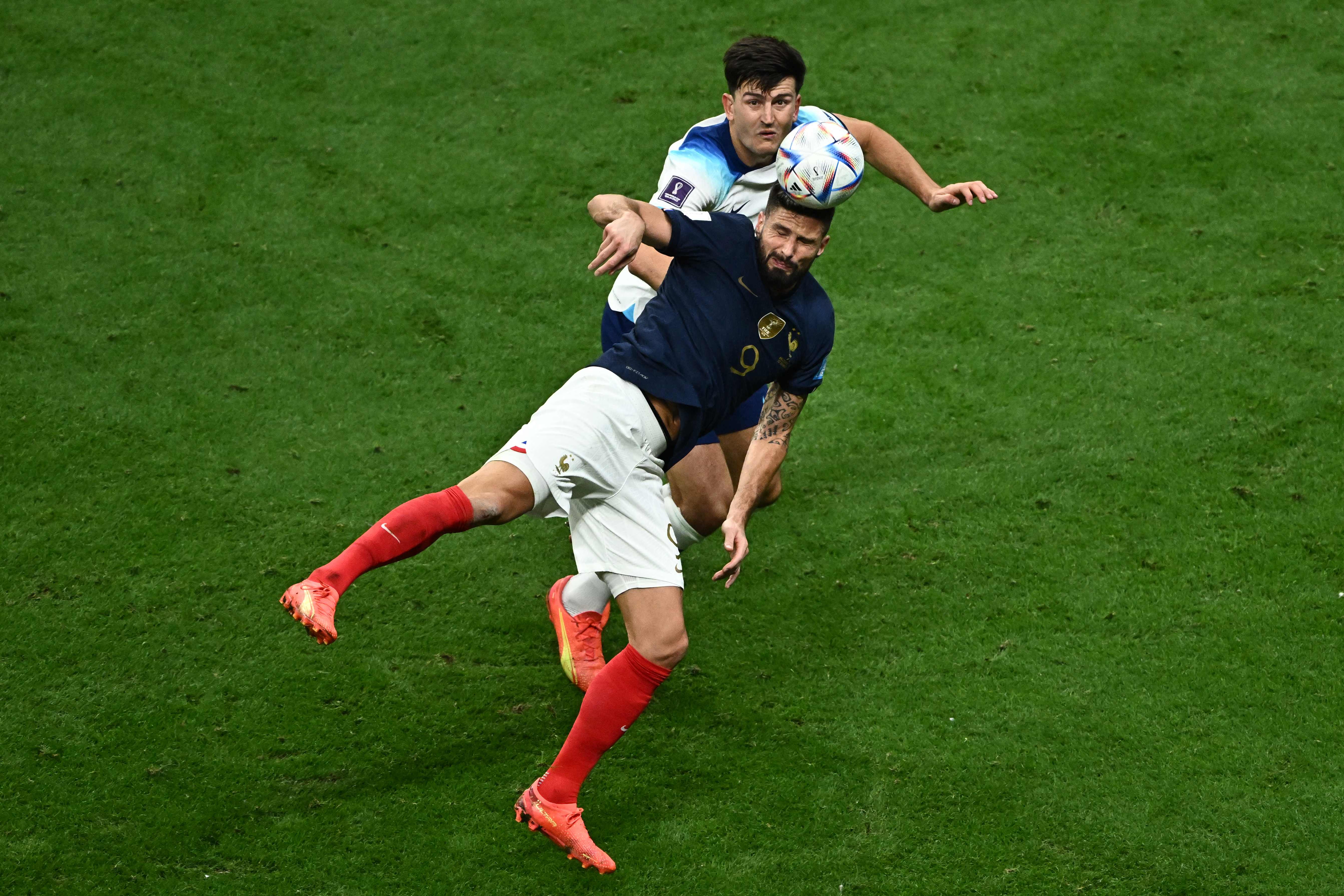 Olivier Giroud heads the ball as he is marked by England's defender