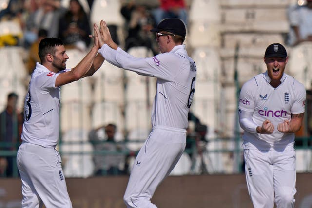 England’s Mark Wood, left, celebrates after taking a wicket (Anjum Naveed/AP)