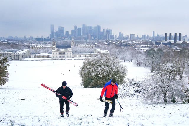 Two skiiers climb a hill through the snow in Greenwich Park, south-east London (Victoria Jones/PA)