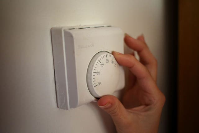 A person using a central heating thermostat (Steve Parsons/PA)