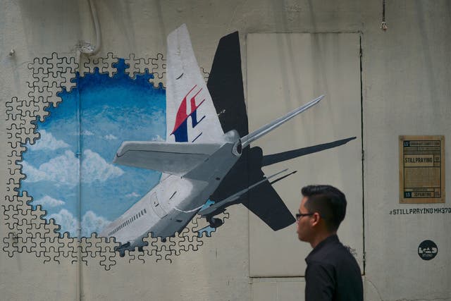 <p>File photo: A man walks pasts a mural representing the missing Malaysia Airlines flight MH370 in an alley in Shah Alam, on the outskirts of Kuala Lumpur in 2015 </p>
