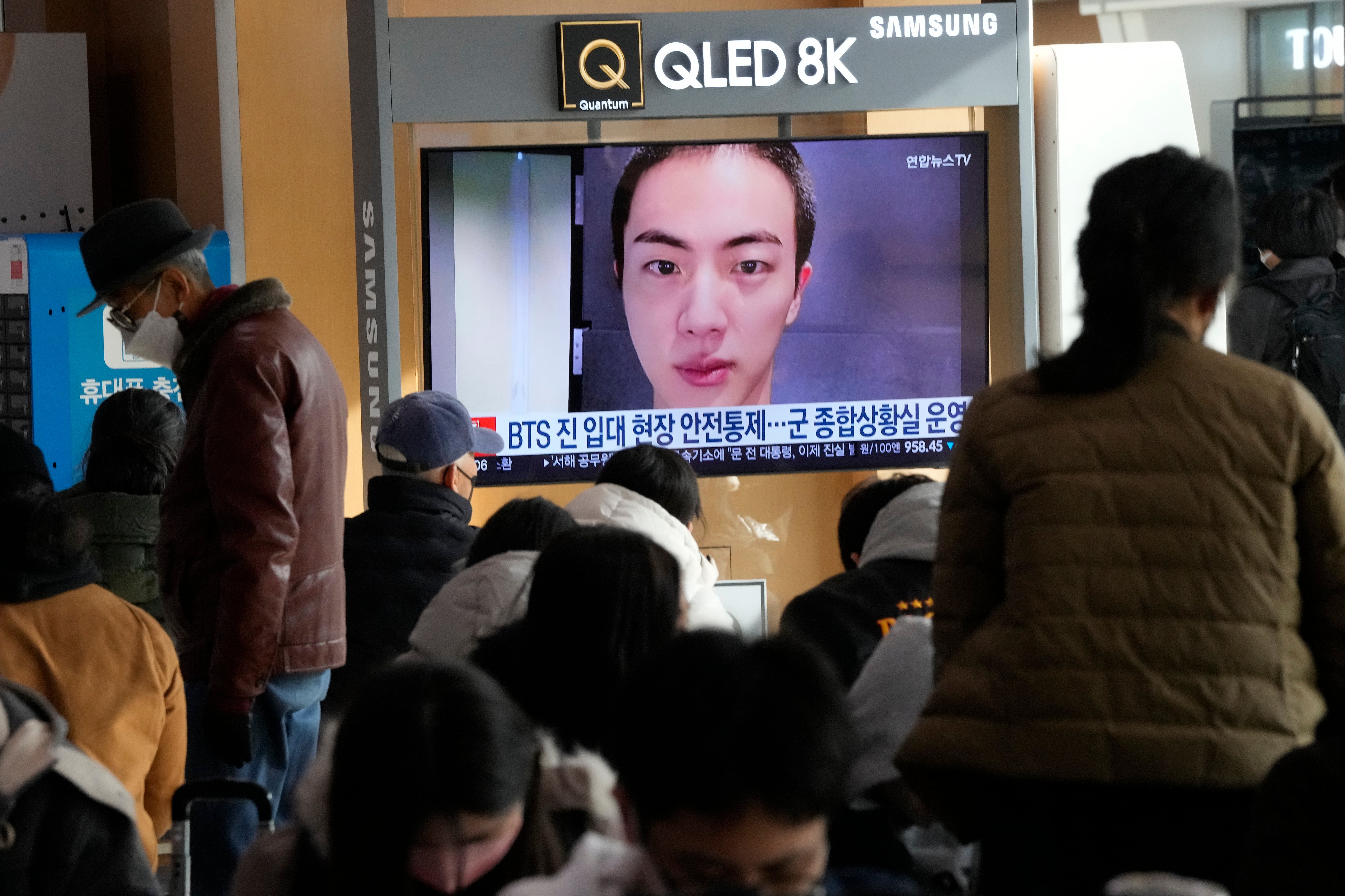 A TV screen shows an image of BTS's member Jin with buzz cut, at the Seoul Railway Station in Seoul, South Korea, Monday, 12 December 2022
