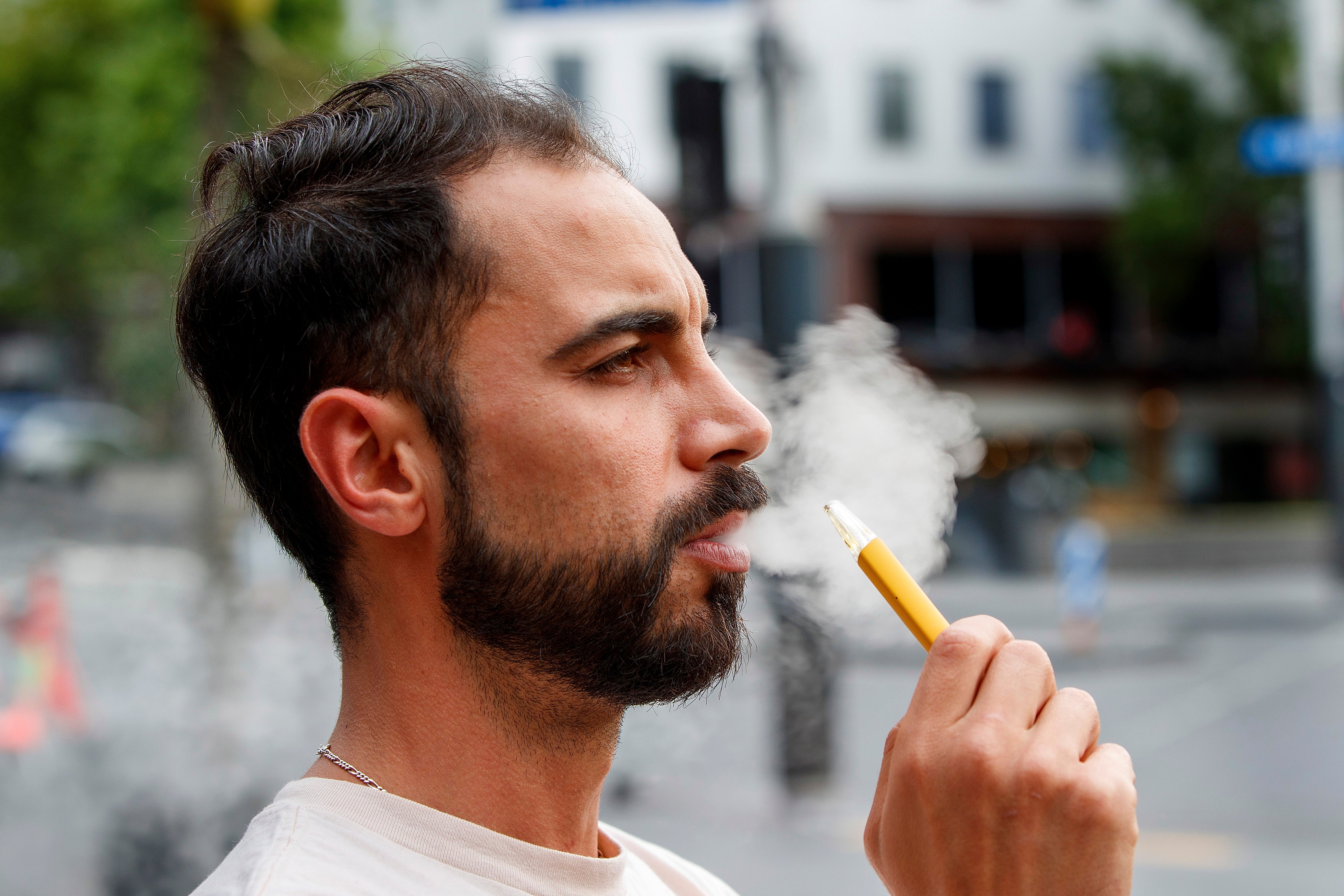 Vaping by a man in a street in Auckland, New Zealand on 9 December 2021