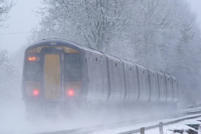 <p>A Southeastern train makes its way through Ashford in Kent as rail services remain disrupted in the icy weather. </p>
