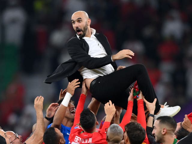 <p>Hitting new heights: Walid Regragui celebrates with his Morocco players after their quarter-final win over Portugal </p>