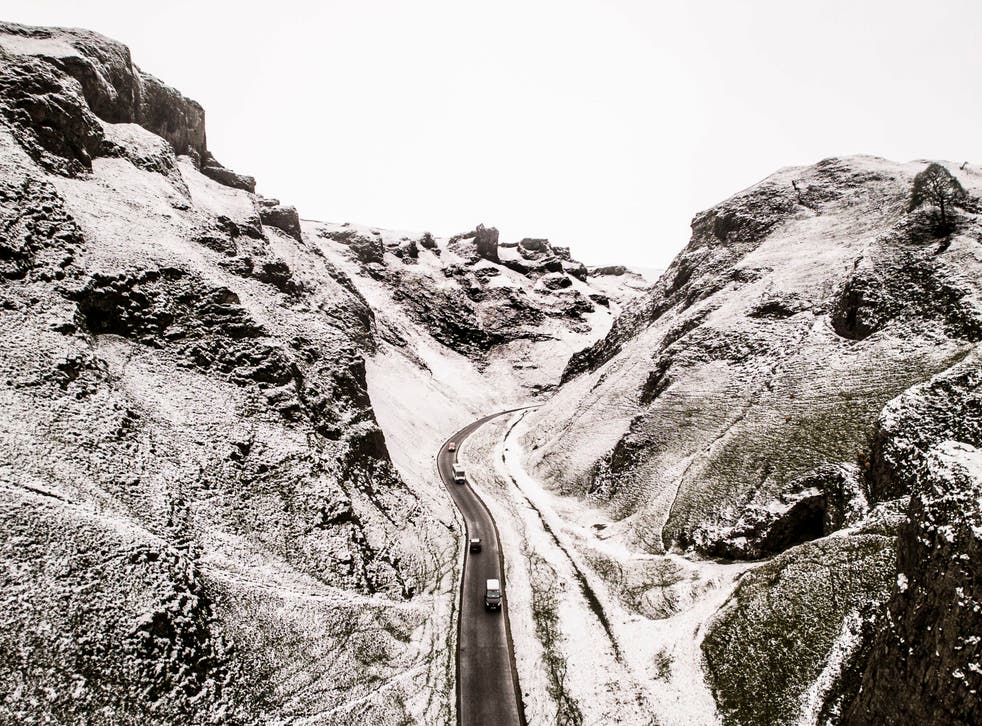 <p>Cars negotiate Winnats Pass in the Peak District as the UK has a snowy week </p>
