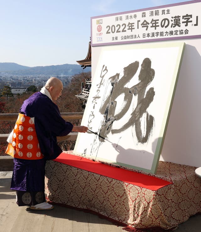 <p>Kiyomizu temple chief Buddhist priest Seihan Mori writes the kanji character ‘sen’, meaning ‘war’, at the temple in Kyoto, western Japan</p>