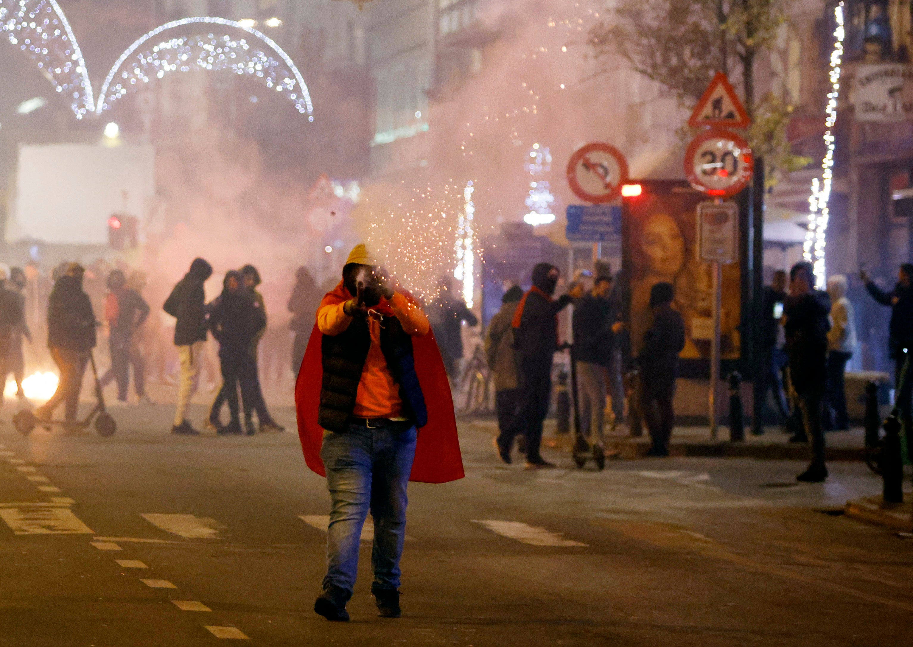 A Morocco fan is pictured with a flare in Brussels after the match