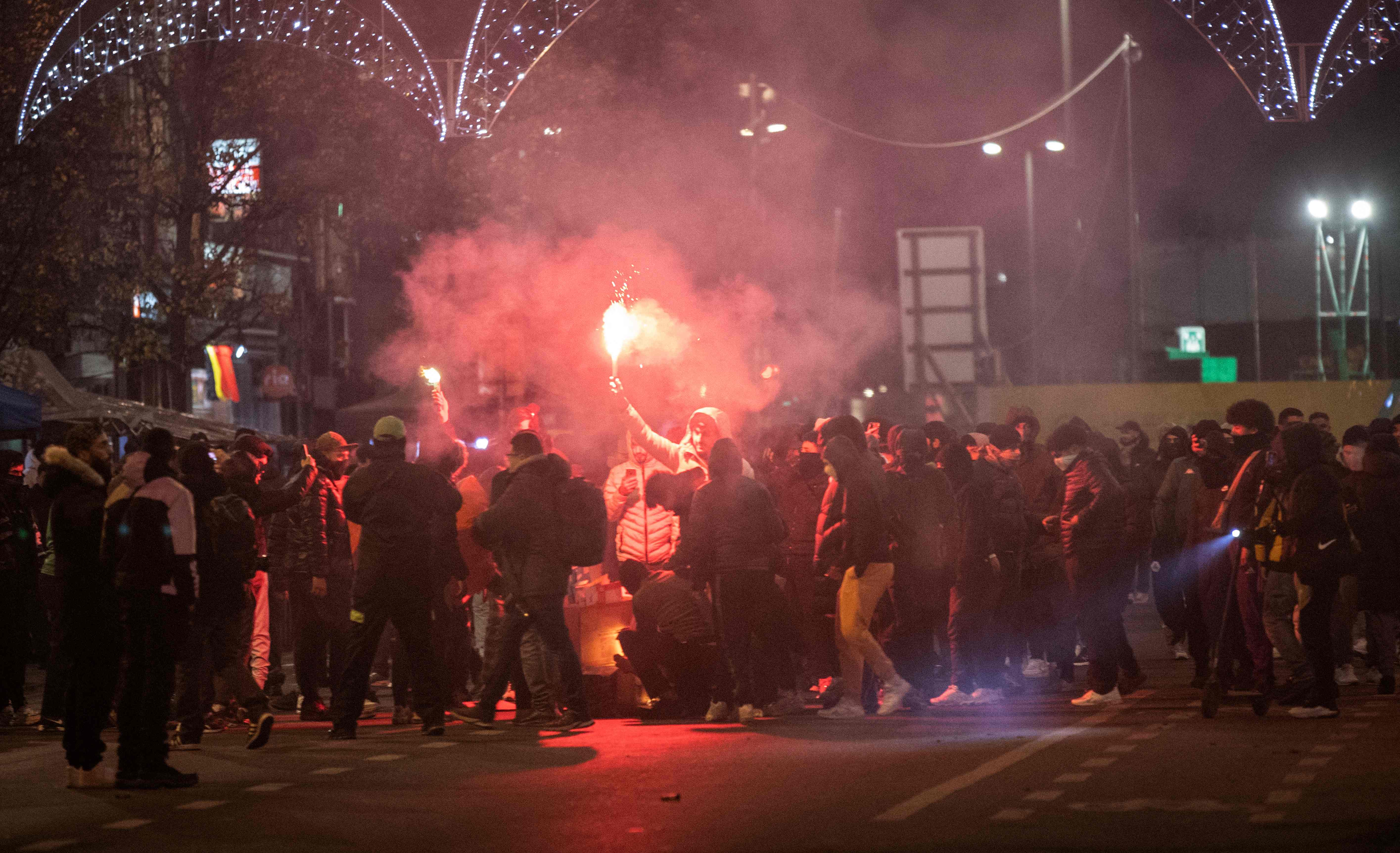 Moroccan supporters in Brussels light flares after their football team lost the Qatar 2022 World Cup semi-final match against France