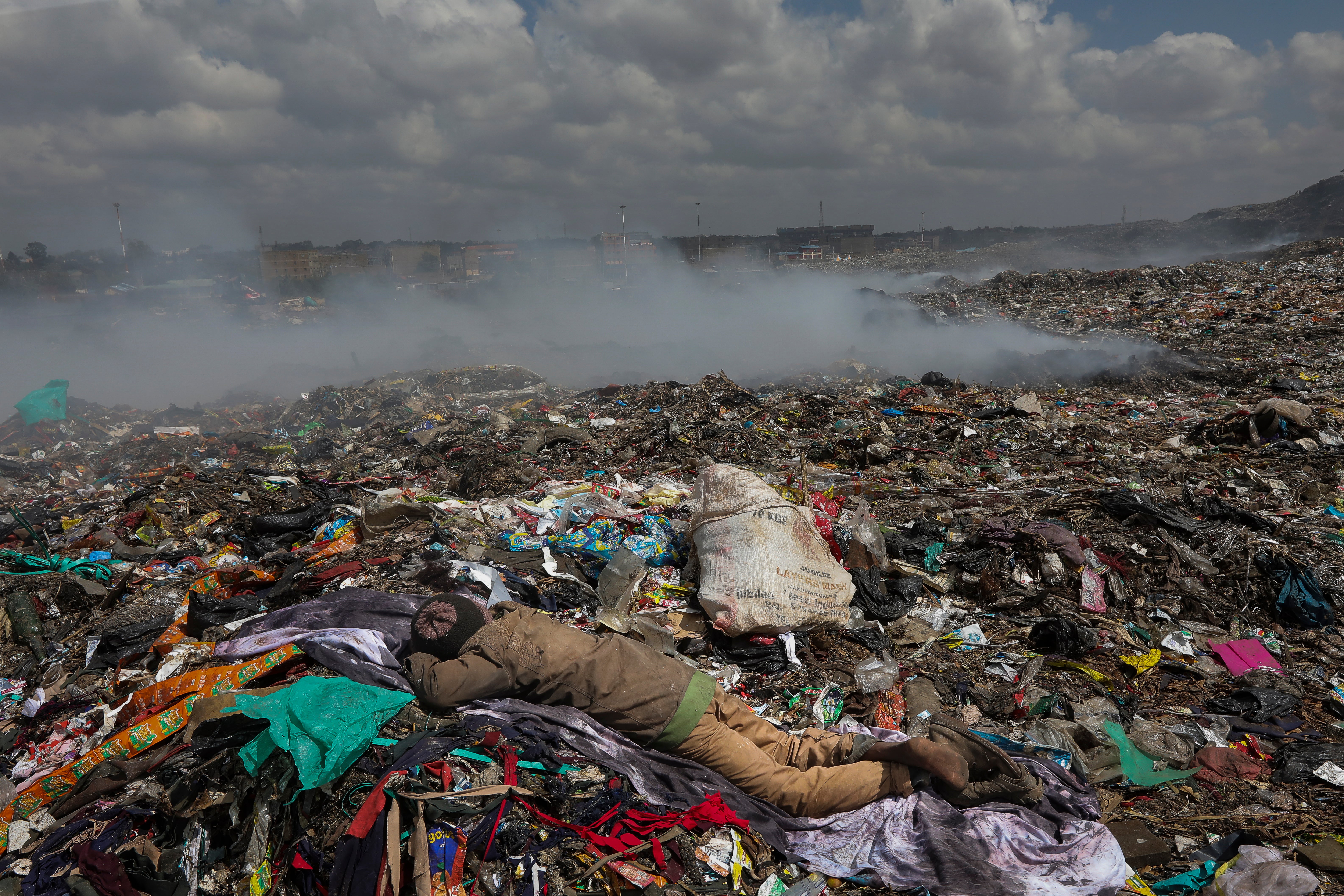 A waste picker takes a nap after walking through the steaming Dandora garbage dump as he scavenges through the landfill for recyclables that can be re-sold in Nairobi, Kenya in March