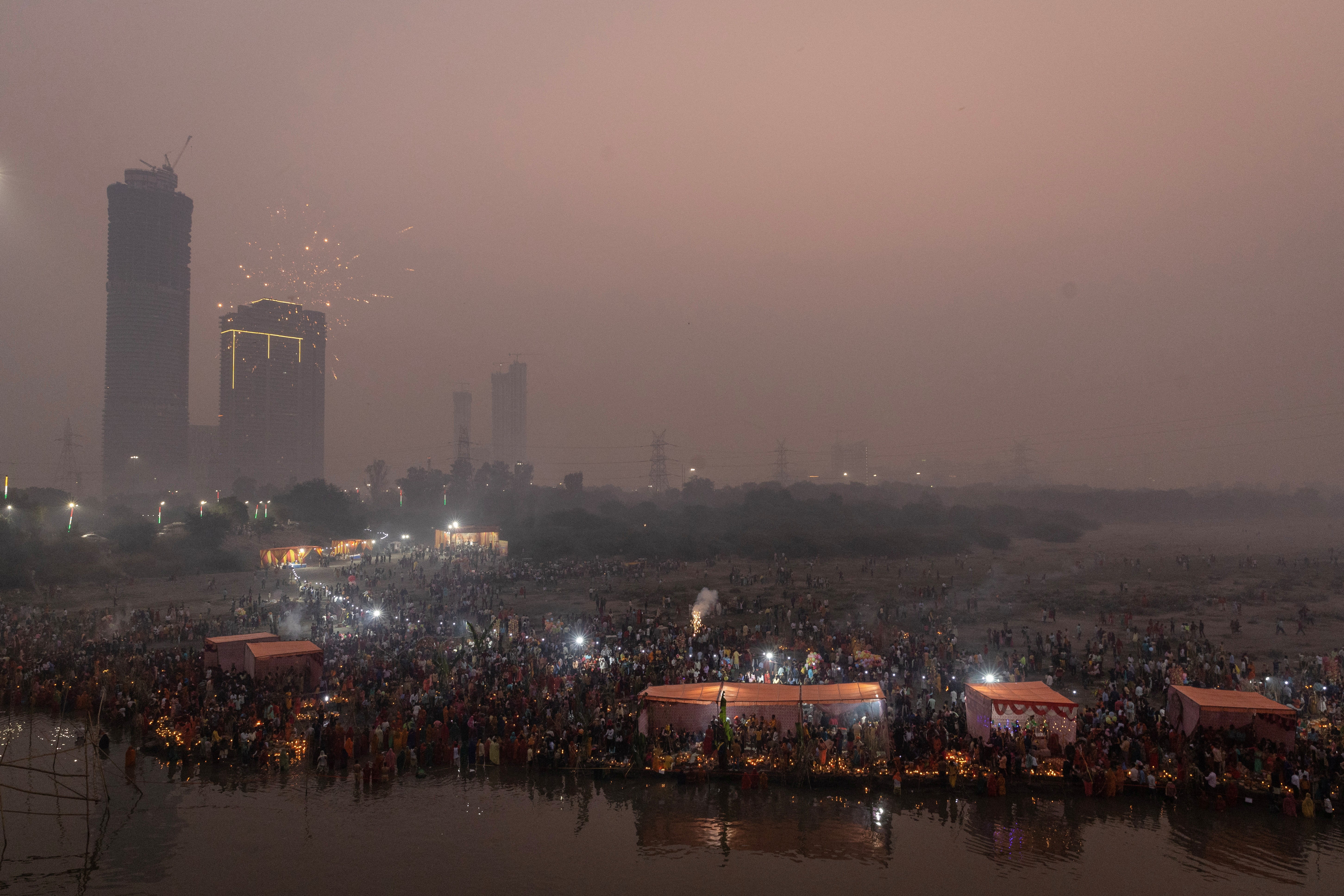 Hindu devotees gather to worship the sun god Surya in the early morning during the Hindu festival of Chhath Puja