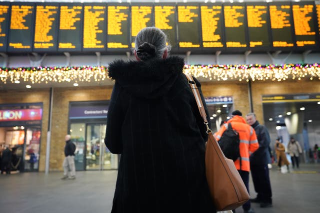 Passengers view departure boards at Kings Cross station in London during a strike by members of the RMT (James Manning/PA)