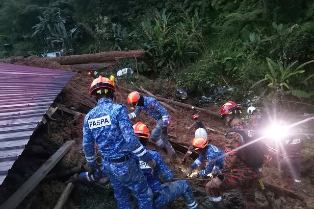 <p>Civil Defense personnel search for survivors buried after a landslide hit a campsite in Batang Kali, Malaysia</p>