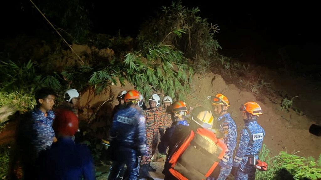 Rescuers work during a rescue and evacuation operation following a landslide at a campsite in Batang Kali, Selangor