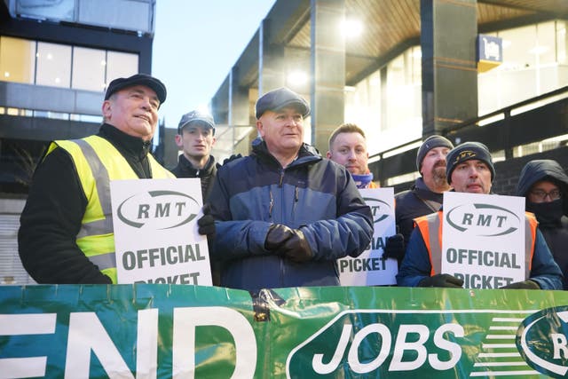 Mick Lynch (centre) general secretary of the Rail, Maritime and Transport union (RMT) joins members on the picket line outside London Euston train station (James Manning/PA)
