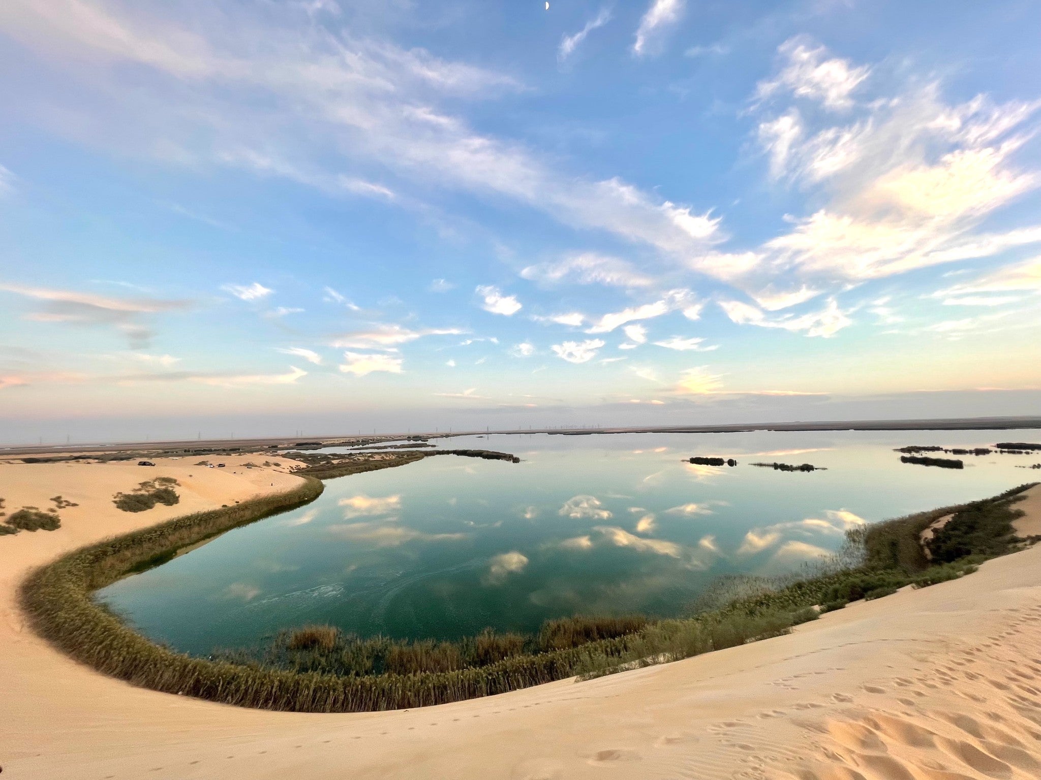 The water reflects the sky in warmer tones as the Sun begins to set on the Yellow Lake