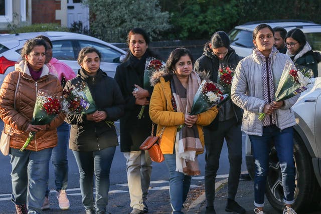 <p>Colleagues of Anju Asok at Kettering General Hospital go to lay flowers at the scene of the murders</p>