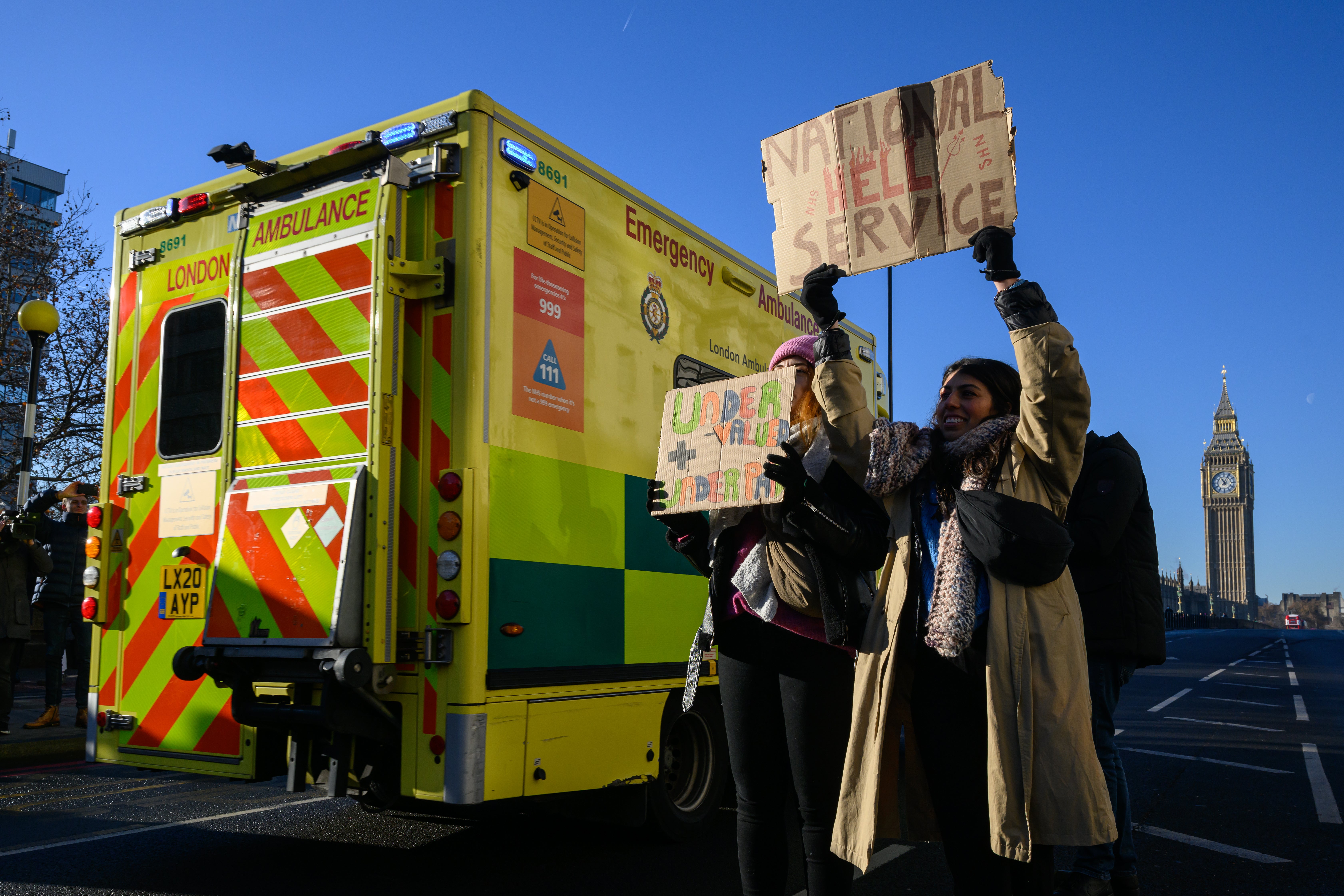 An ambulance drives past as nurses and supporters gather to demonstrate outside St Thomas' hospital in Westminster