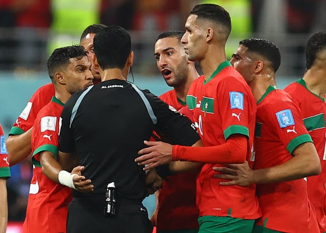 <p>Morocco players remonstrates with the referee Abdulrahman Al Jassim</p>