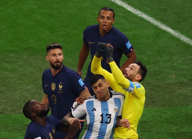 Cristian Romero pushes into Hugo Lloris as he punches the ball away