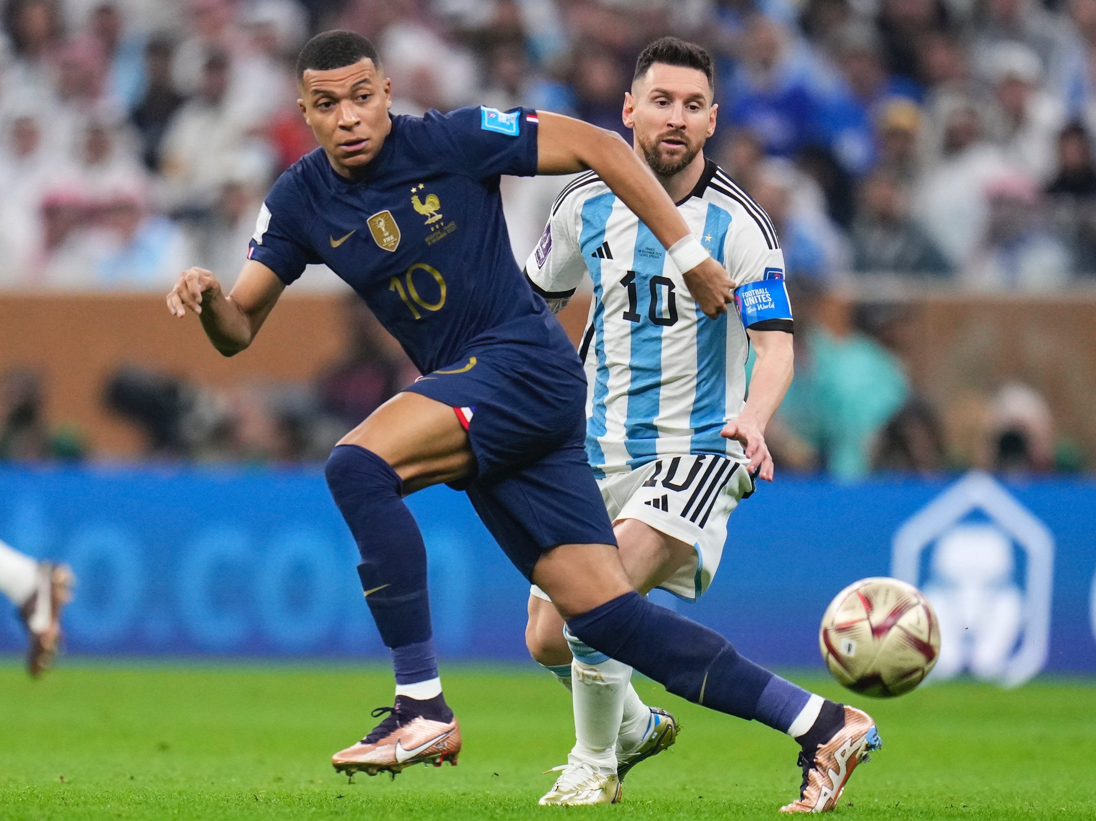 Kylian Mbappe and Lionel Messi go for the ball