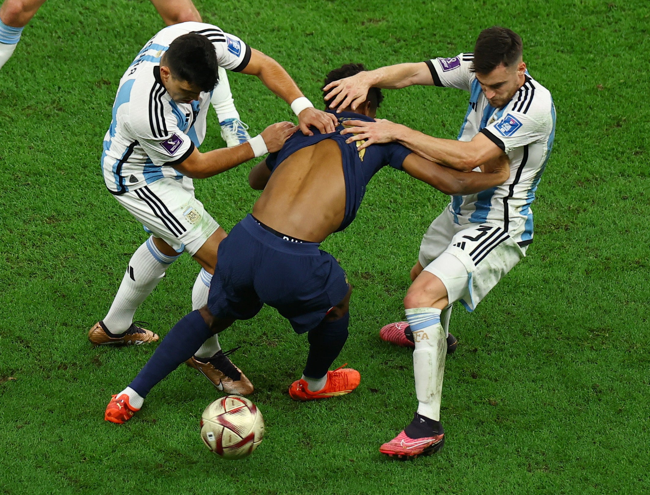 France’s Kingsley Coman has his shirt pulled up by two Argentina players