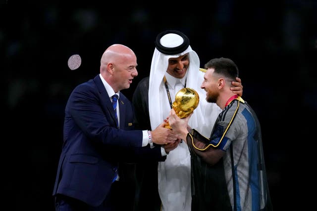 FIFA president Gianni Infantino, left, and The Emir of Qatar, Sheikh Tamim bin Hamad Al Thani, present Argentina captain Lionel Messi with the World Cup trophy (Nick Potts/PA)