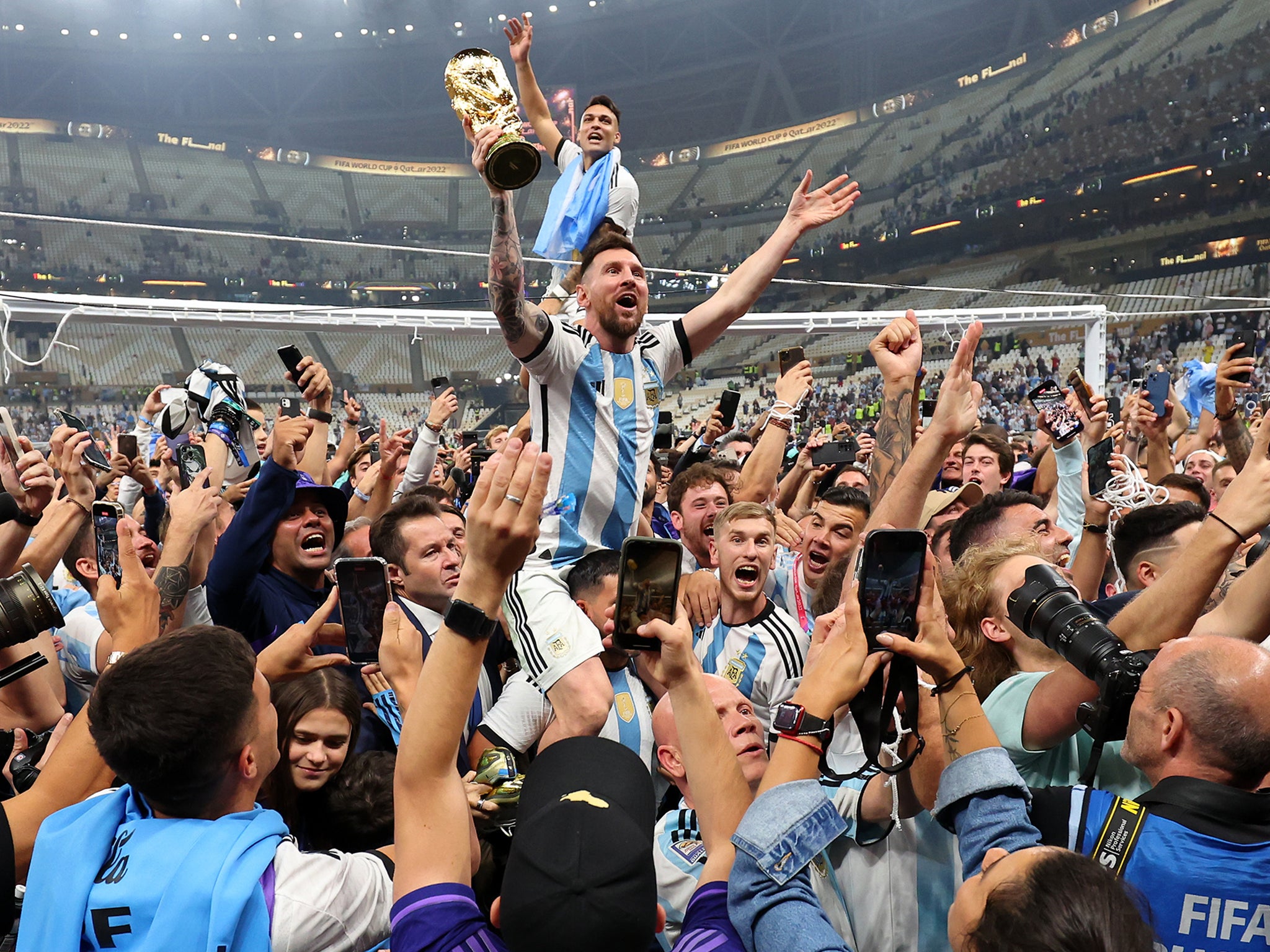 Lionel Messi raises the World Cup trophy into the air during Argentina’s celebrations