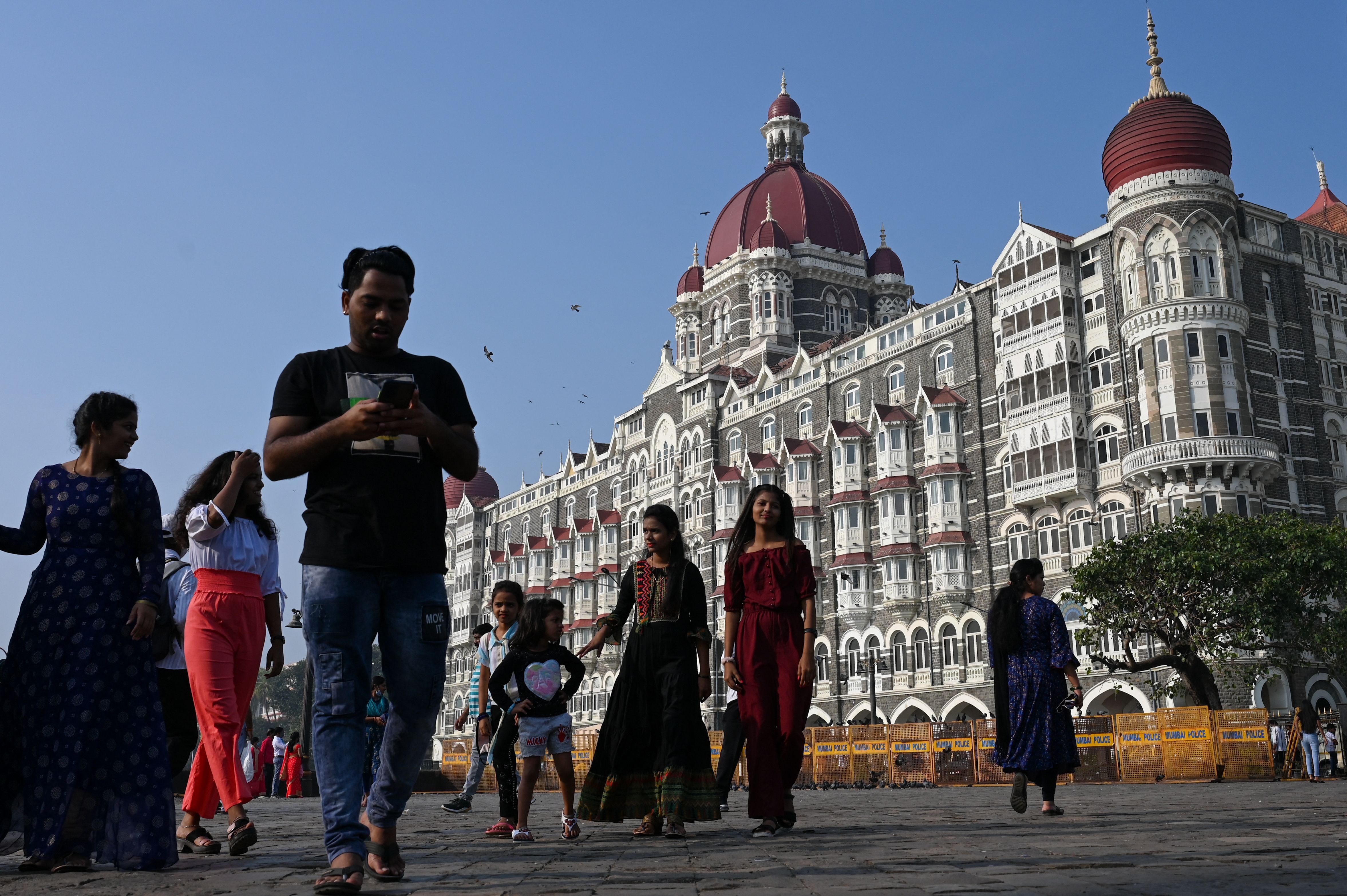 Tourists visit near the Taj Mahal Palace hotel, one of the sites of the 2008 terrorist attacks, in Mumbai on 26 November 2021