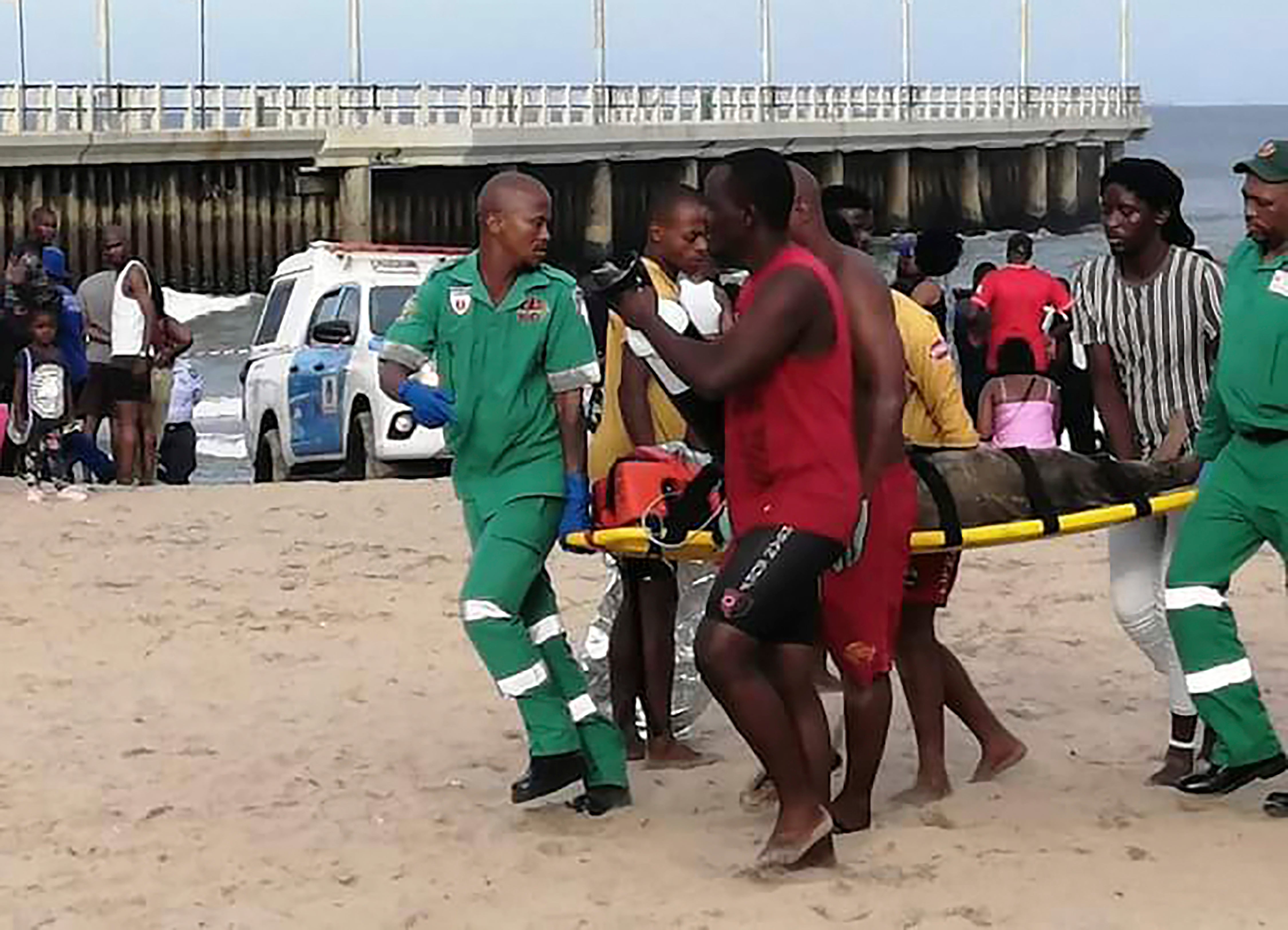 Paramedics carry a person on a stretcher on the Bay of Plenty Beach in Durban, South Africa
