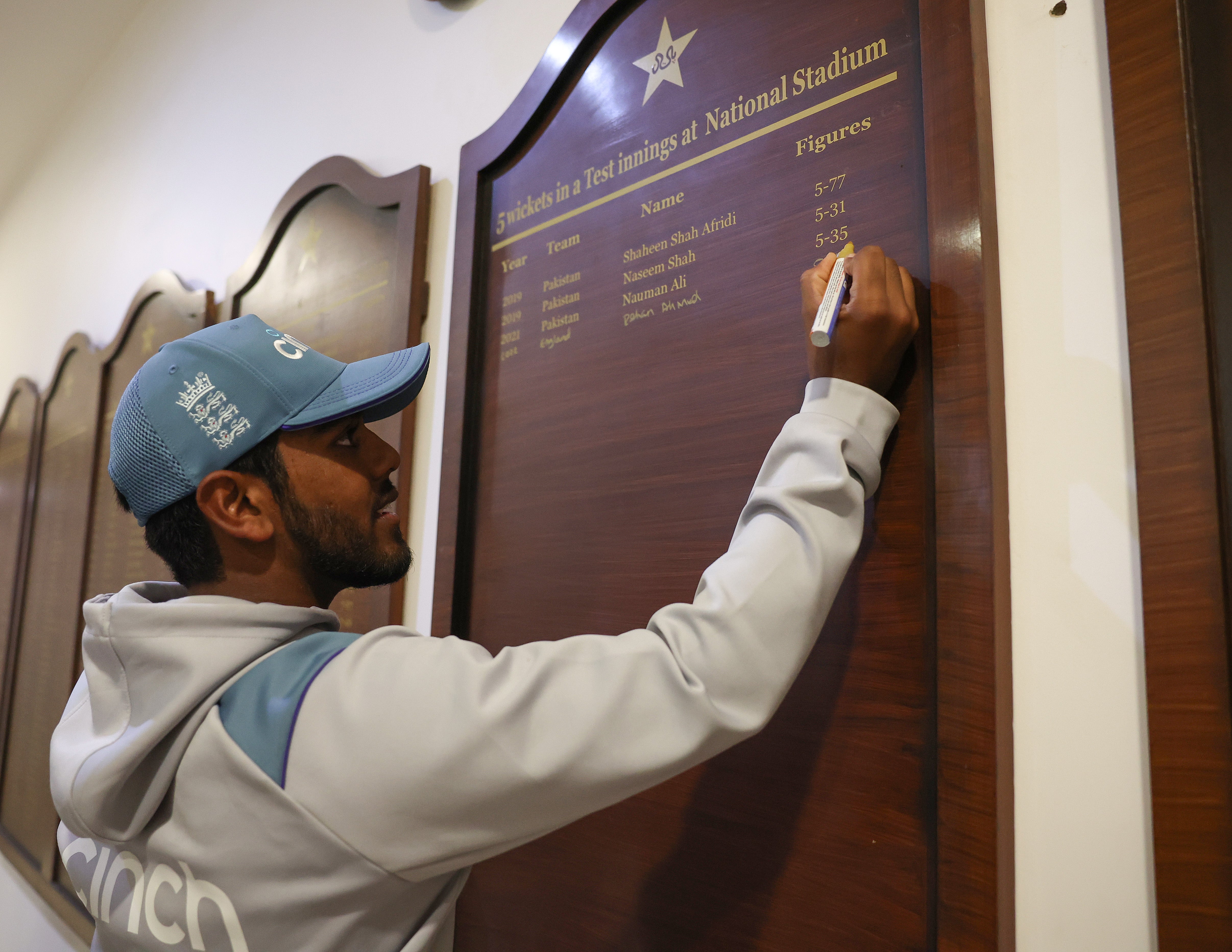 Rehan Ahmed of England signs a honours board to commemorate his five wickets