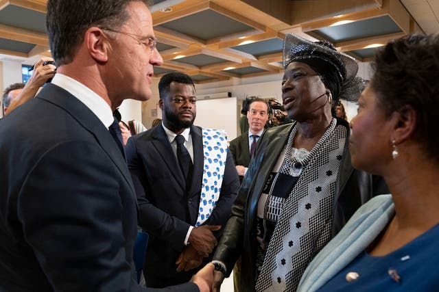 <p>Dutch PM Rutte, left, shakes hands with Marian Markelo, a Winti Priest, an Afro-Surinamese traditional religion, second right, after apologising for the Netherlands’ historical role in slavery</p>