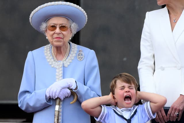 <p>Prince Louis holds his ears as he stands next to Queen Elizabeth II to watch a special flypast, from Buckingham Palace balcony, as part of the platinum jubilee celebrations</p>
