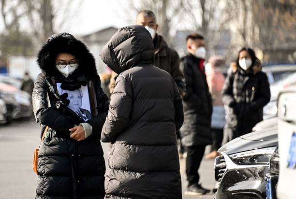 A woman holds a picture frame of a loved one at a crematorium in Beijing on 20 December 2022