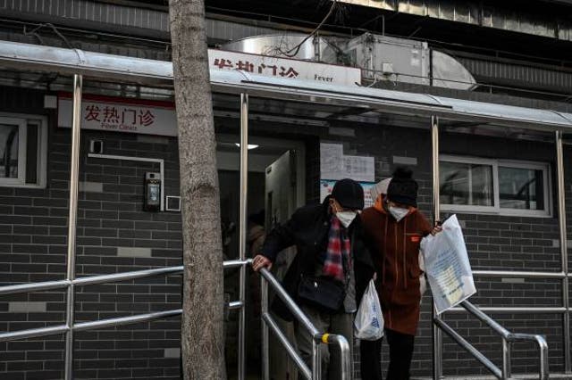 <p>People walk out from a fever clinic amid the Covid-19 pandemic in Beijing on 20 December 2022.</p>