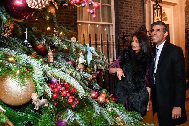 Prime Minister Rishi Sunak and wife Akshata Murty look at the Christmas tree outside No10. The Prime Minister and his family will spend Christmas in Yorkshire (Toby Melville/PA)