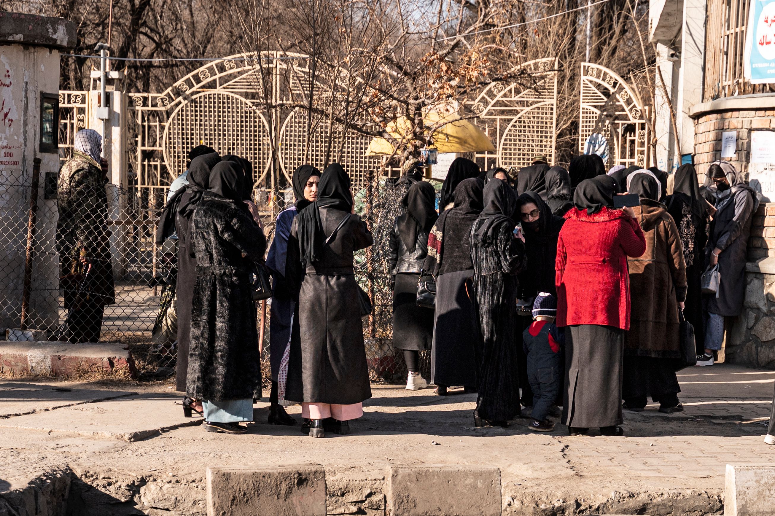 Students stopped by Taliban forces stand next to a university in Kabul on Wednesday