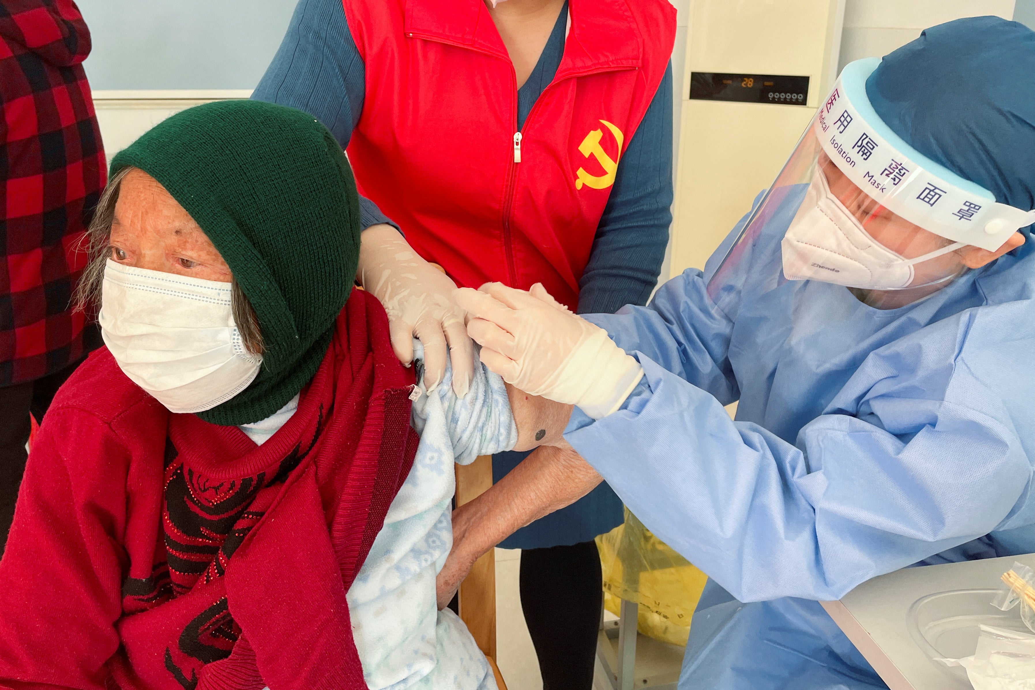 An elderly resident is vaccinated against Covid in Zhongmin village near Shanghai on Wednesday
