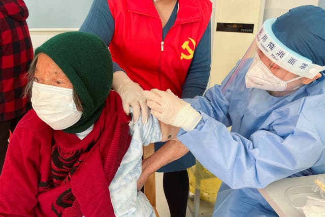 <p>An elderly resident is vaccinated against Covid in Zhongmin village near Shanghai on Wednesday</p>