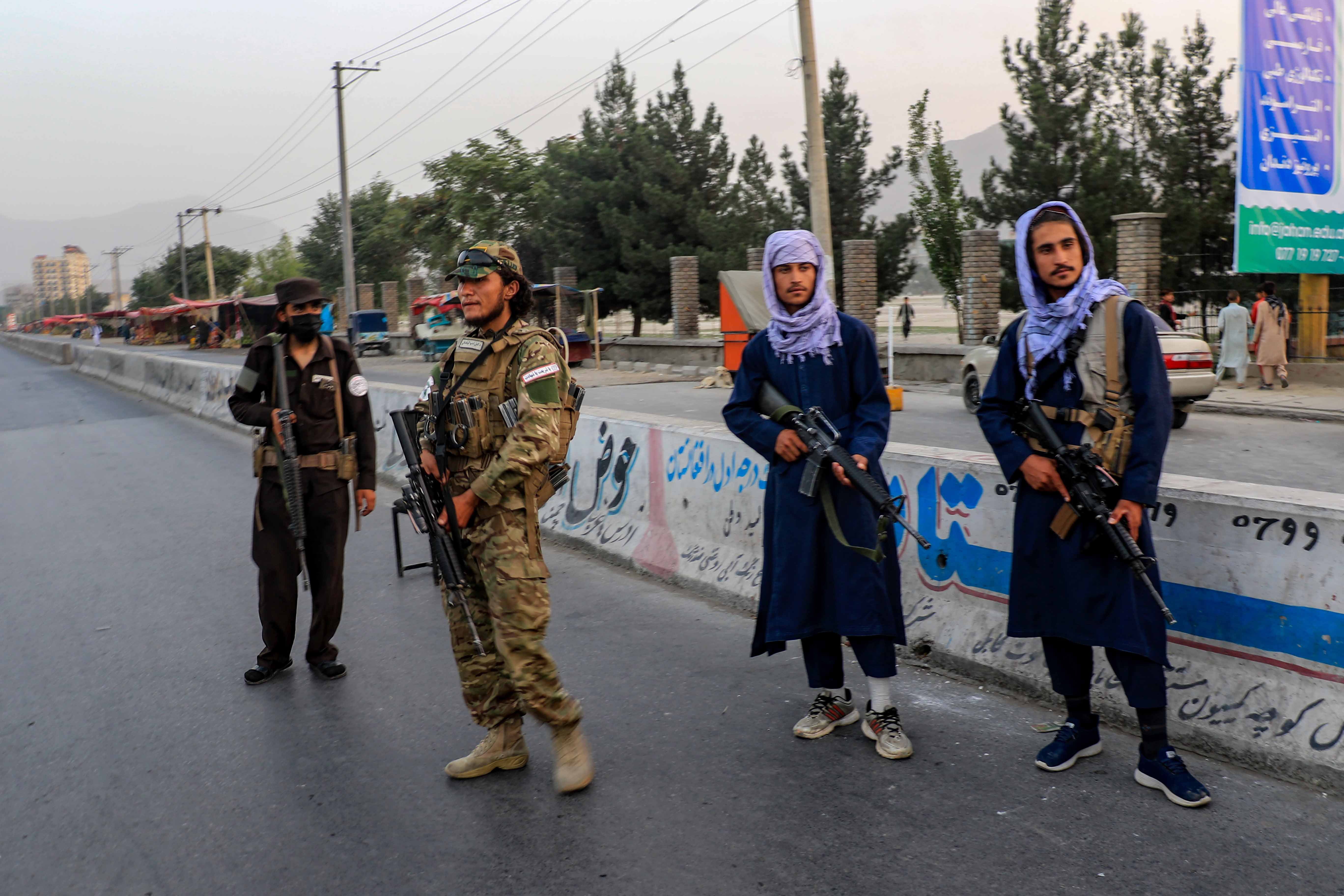 <p>Taliban stand guard outside Kabul University</p>