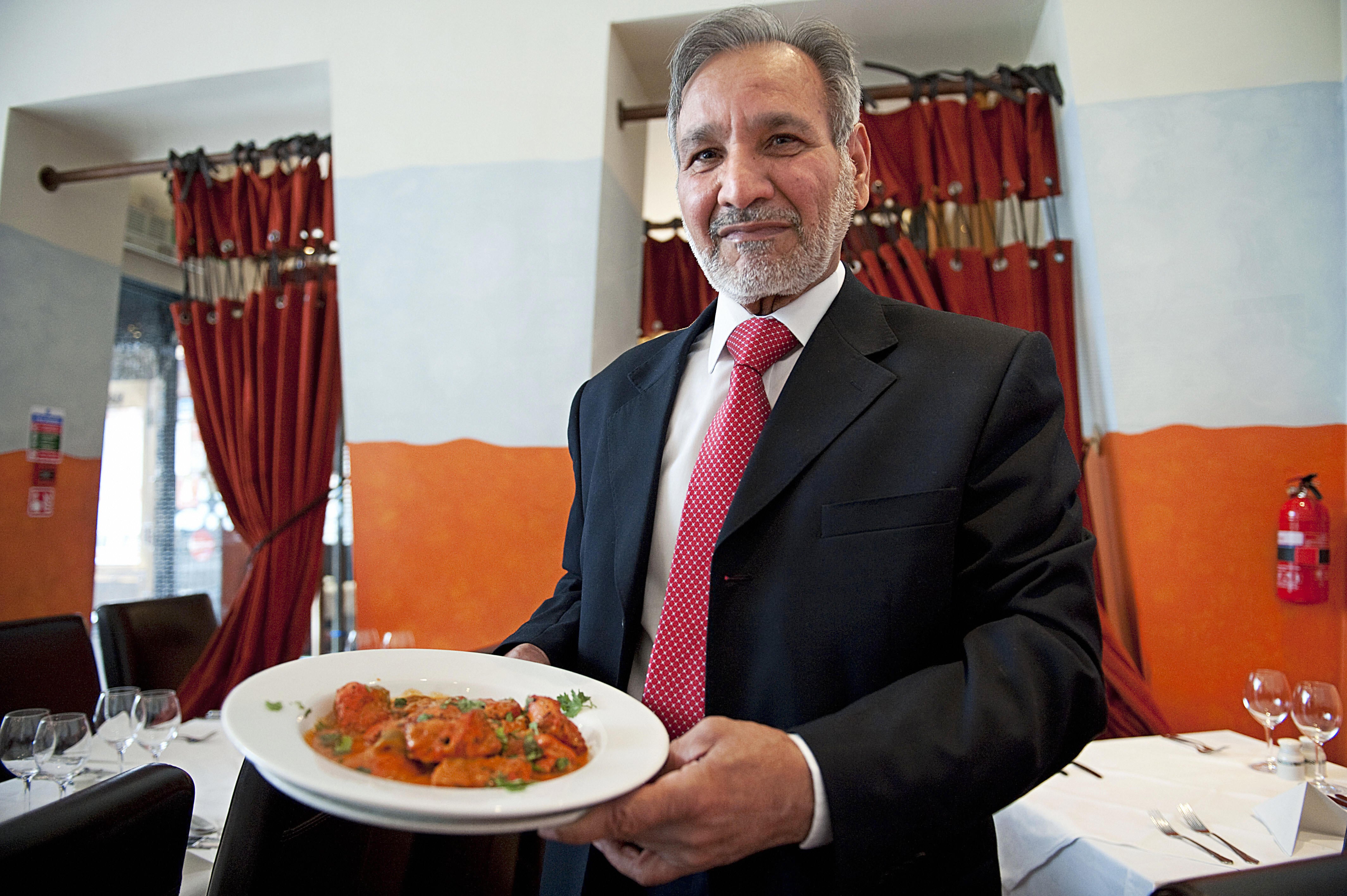 Ahmed Aslam Ali, the owner of the Shish Mahal restaurant in Glasgow, is pictured with a plate of chicken tikka masala in his restaurant in 2009