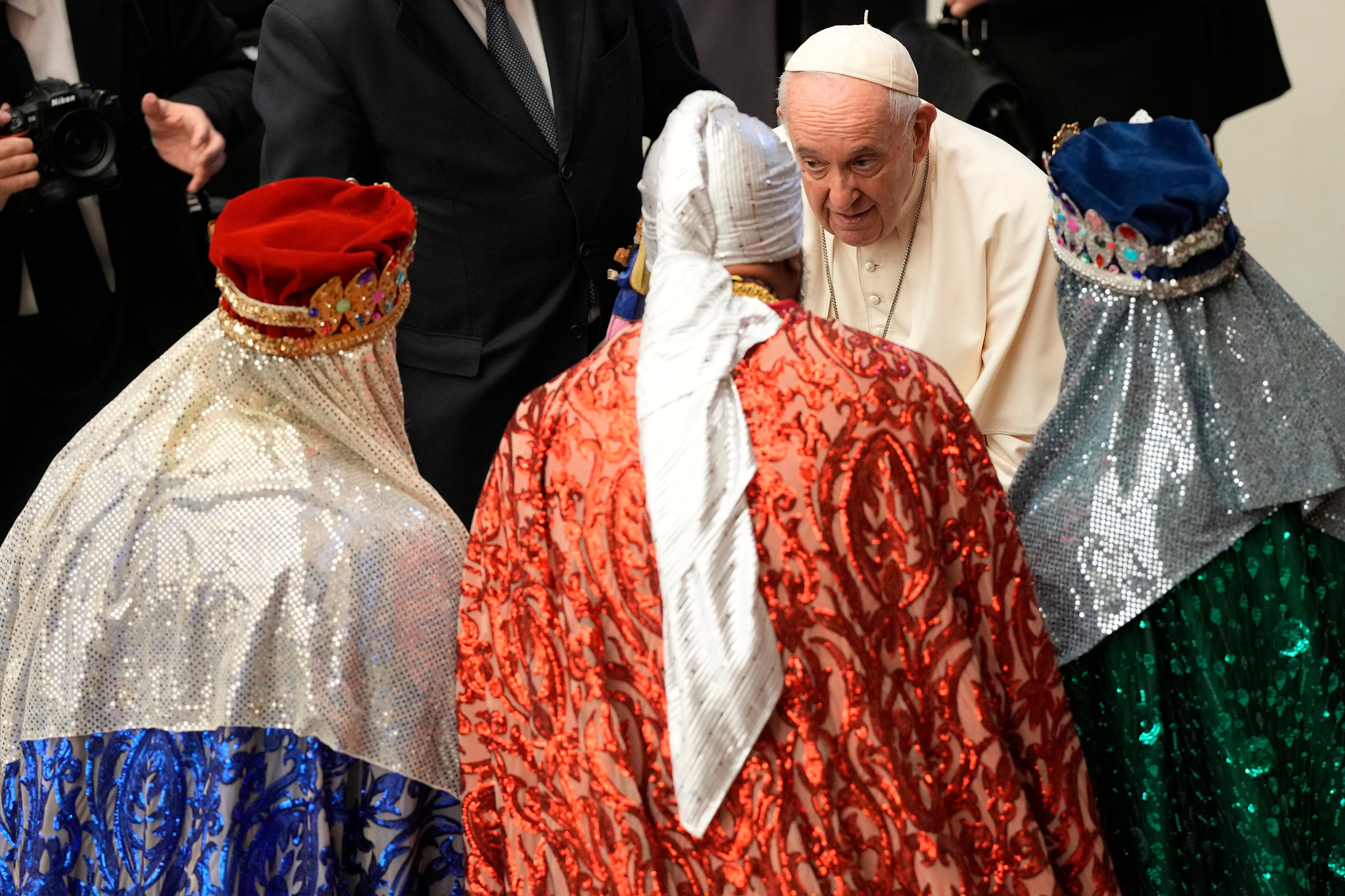 Pope Francis talks with faithful dressed as the Three Wise Men at the end of his weekly general audience
