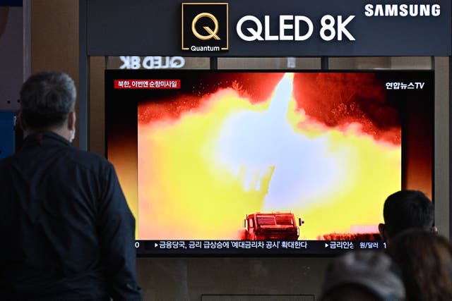<p>A man watches a news broadcast showing a photo of a North Korean missile test, at a railway station in Seoul</p>