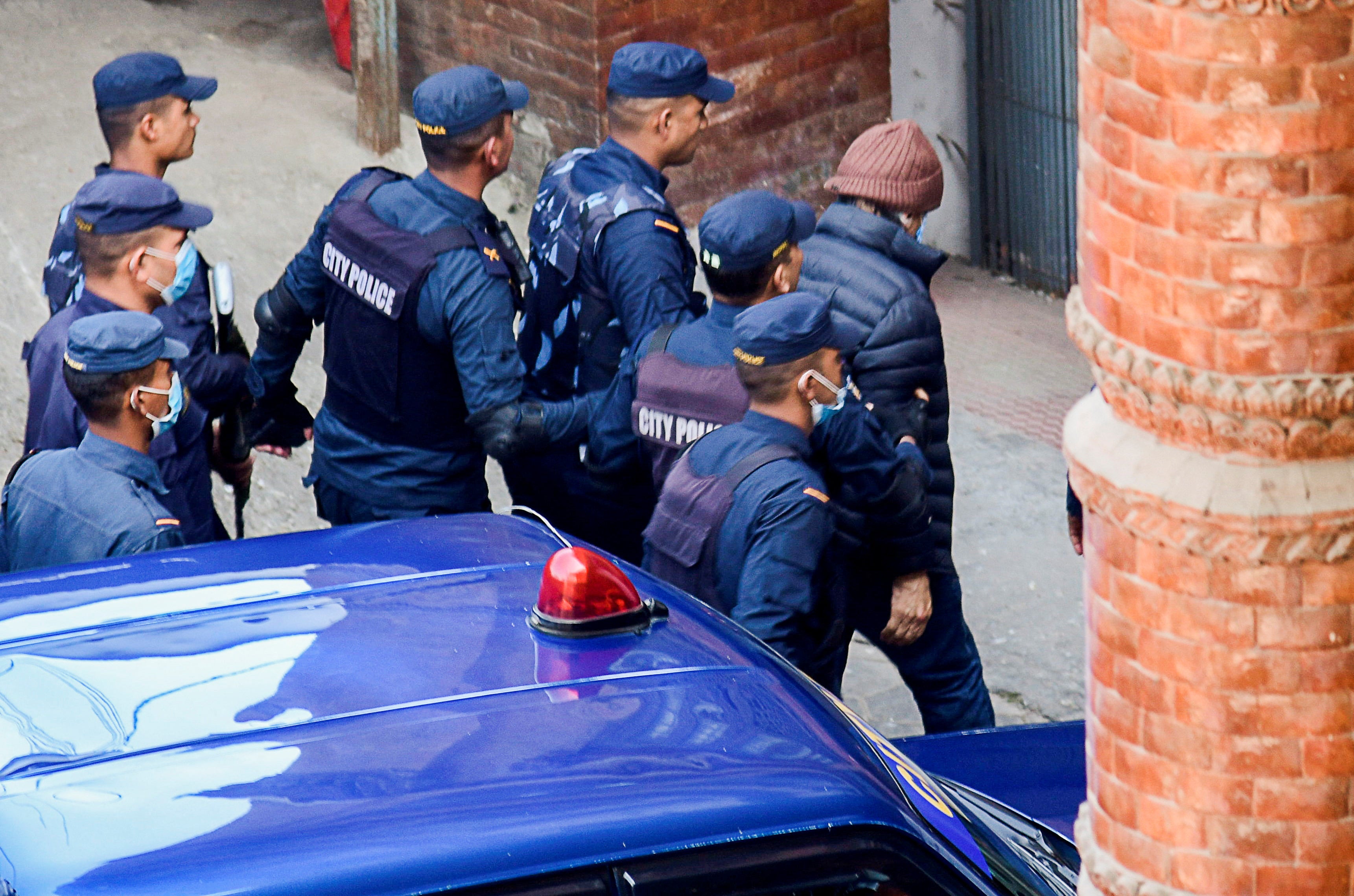 Police officers escort Charles Sobhraj, a French national known as 'The Serpent', suspected of killing over 20 Western backpackers across Asia