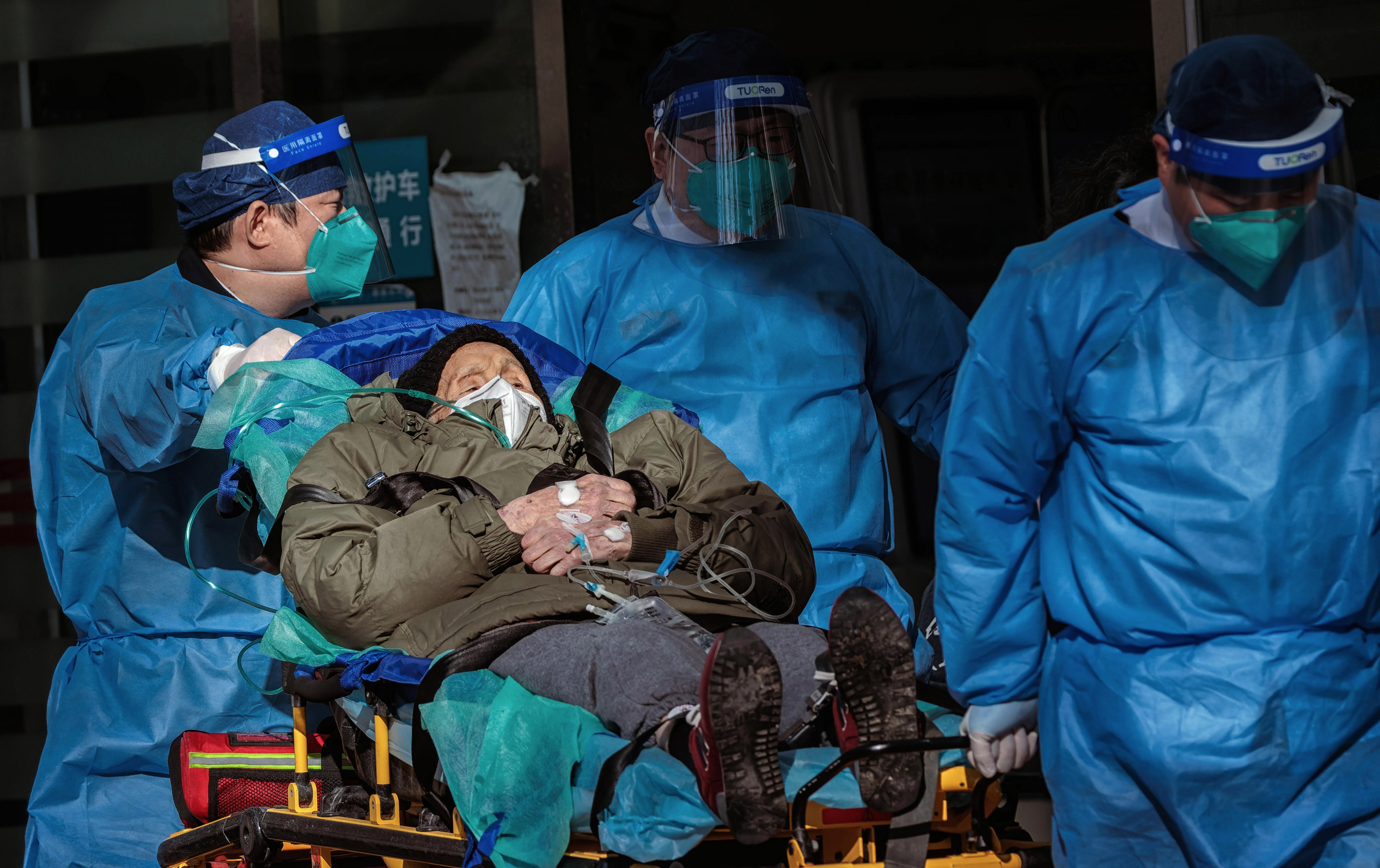 Health workers carry a patient into hospital in Shanghai on Friday amid a Covid surge in China