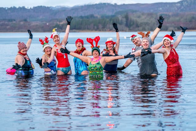 <p>Members of the Loch Insh Dippers wild swim group take part in a Christmas-themed swim in Loch Insh in the Cairngorms National Park near Aviemore, Scotland</p>