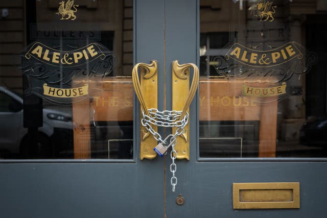 <p>Chains secure the doors of a closed pub in London </p>
