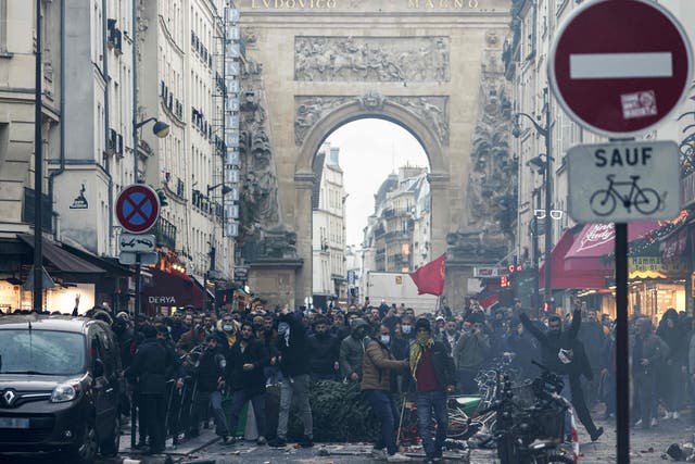 <p>Protestors stand in front of riot police officers following a statement by French interior minister Gerald Darmanin</p>